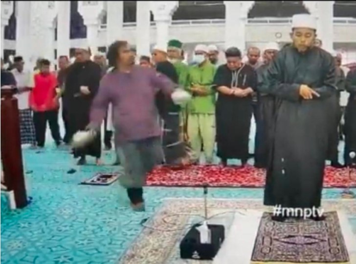 شاهد : شخص يقتحم صفوف المصلين ويعتدي على إمام المسجد أثناء صلاة الفجر (فيديو)